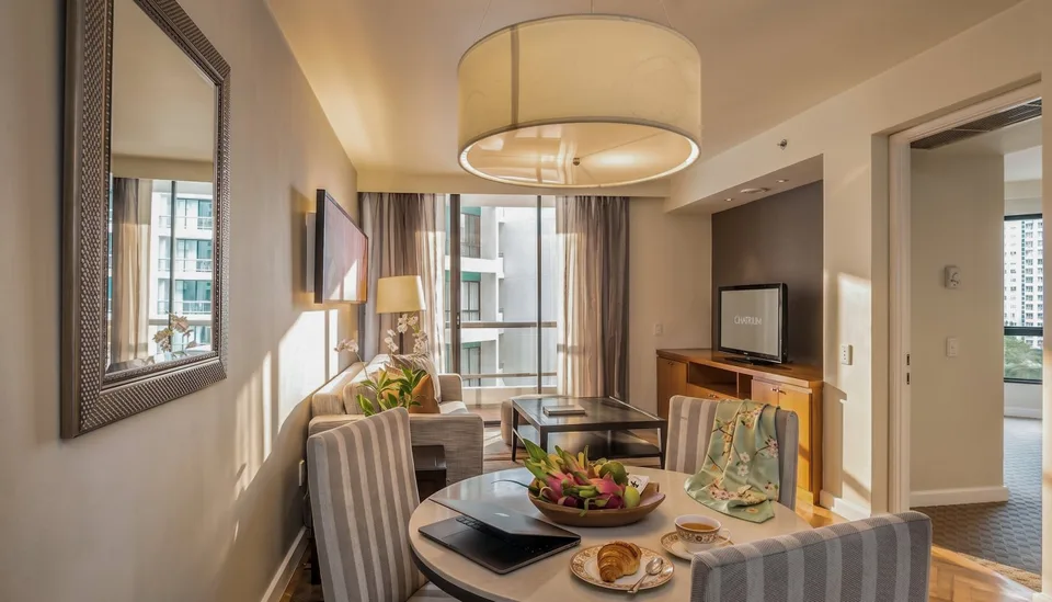 Living and dining area in a Deluxe 1-Bedroom King at Chatrium Sathon Bangkok.