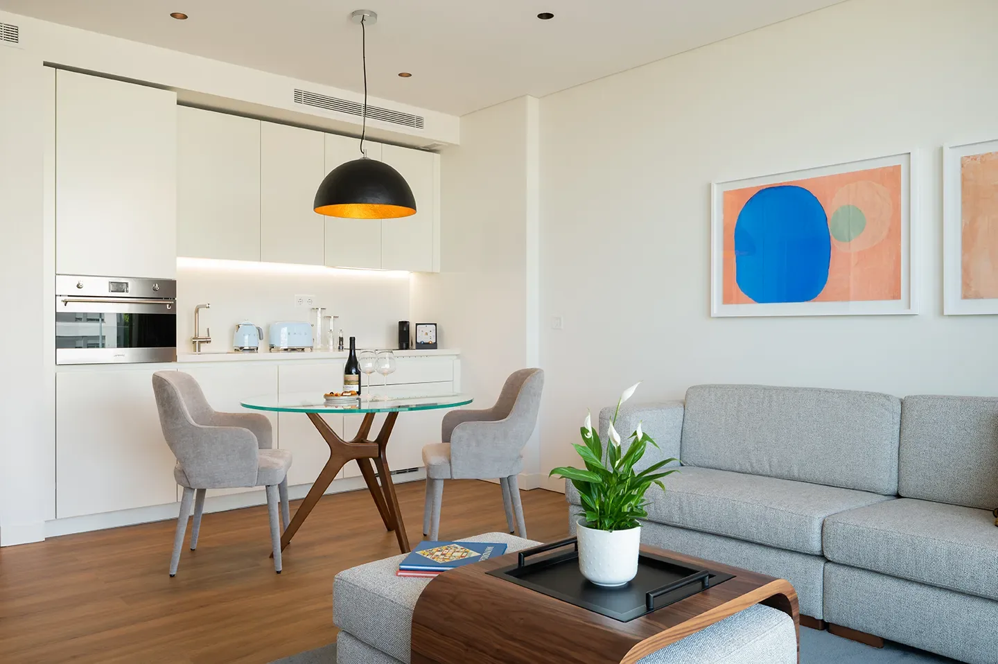 Kitchen, dining table and sofa in a one-bedroom apartment at Martinhal Lisbon Oriente.