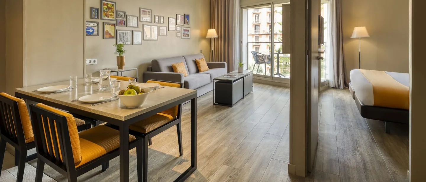Citadines Ramblas Barcelona 的 1-Bedroom Apartment 起居用餐区,可见卧室入口。