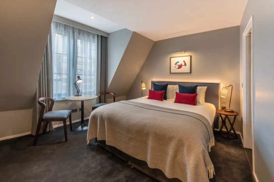 Bed and seating in a Superior King Room at The Resident Covent Garden.